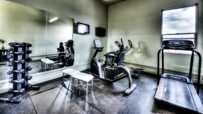 a gym with a treadmill and ellipticals in a room at Podollan Inn & Spa - Grande Prairie in Grande Prairie