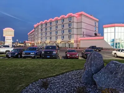 a parking lot with cars parked in front of a hotel at St. Albert Inn & Suites in St. Albert