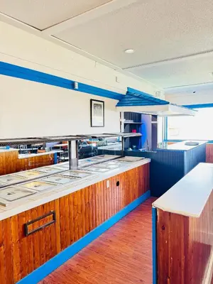 a kitchen with wooden cabinets and a counter top at Ramada by Wyndham Dawson Creek in Dawson Creek
