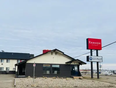 a building with a sign in front of it at Ramada by Wyndham Dawson Creek in Dawson Creek