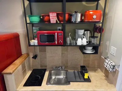 a small kitchen with a sink and a microwave at Lido Motel in Radium Hot Springs