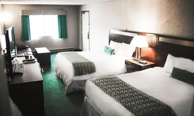 a hotel room with two beds and a window at Ramada by Wyndham in Quesnel