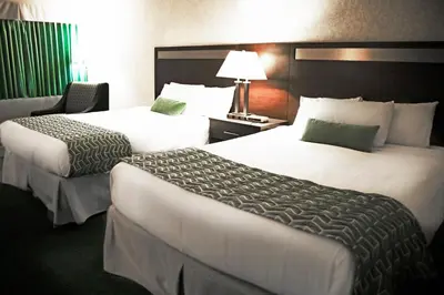 a hotel room with two beds and a lamp at Ramada by Wyndham in Quesnel