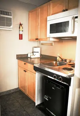 a small kitchen with a sink and a stove at Ramada by Wyndham in Quesnel