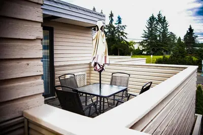 a patio with a table and chairs and an umbrella at Ramada by Wyndham in Quesnel