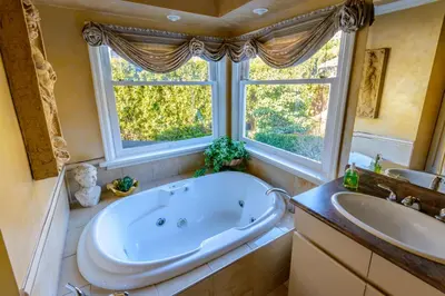 a bathroom with a tub and a sink and a window at Crystal's View Bed & Breakfast in North Vancouver