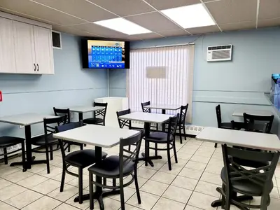 a dining room with tables and chairs and a tv at Canadian Motor Inn in Grande Prairie