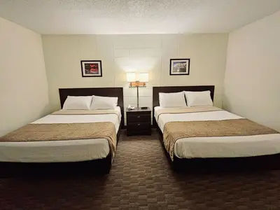 a hotel room with two beds in a room at Canadian Motor Inn in Grande Prairie