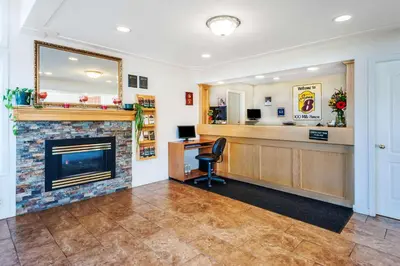 a waiting room with a fireplace and a bar at Super 8 by Wyndham 100 Mile House in One Hundred Mile House