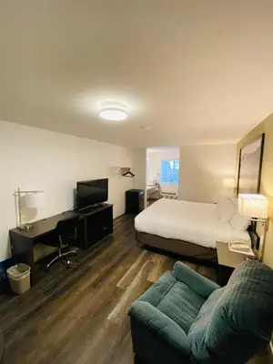 a hotel room with a bed and a couch at Super 8 by Wyndham 100 Mile House in One Hundred Mile House
