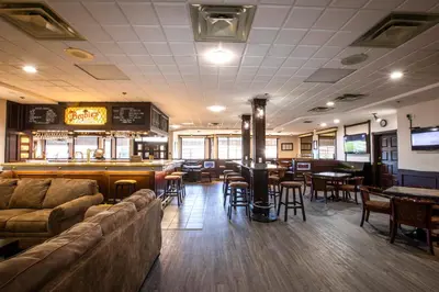 a restaurant with a bar and some tables and chairs at Tower Inn & Suites in Quesnel