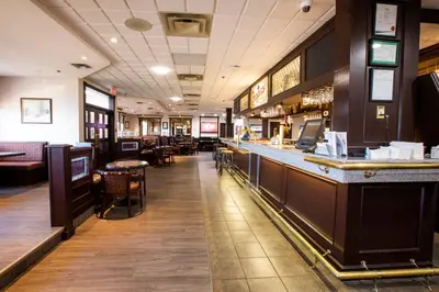 a restaurant with a bar and some tables and chairs at Tower Inn & Suites in Quesnel