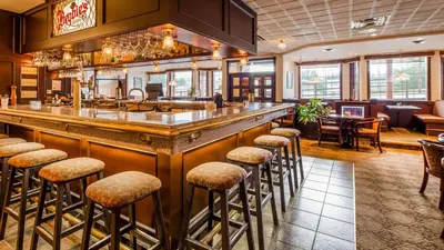 a bar in a restaurant with stools at Tower Inn & Suites in Quesnel