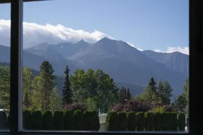 a view of a mountain range from a window at Prestige Hudson Bay Lodge & Conference Centre, WorldHotels Crafted Collection in Smithers