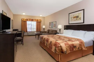 a hotel room with a large bed and a television at Ramada by Wyndham Brooks in Brooks