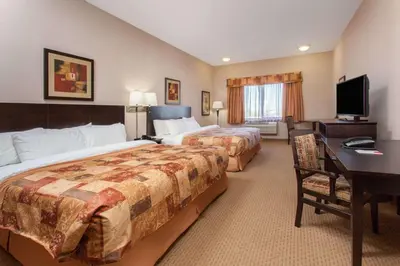 a hotel room with two beds and a desk at Ramada by Wyndham Brooks in Brooks