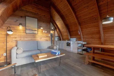 a living room with a couch and a table at Ocean Village Resort in Tofino