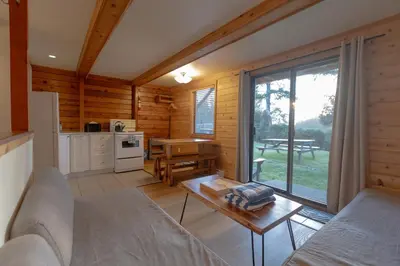 a living room with a couch and a table at Ocean Village Resort in Tofino