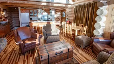 a living room with leather furniture in a log cabin at Snow Creek Cabins by Fernie Lodging Co in Fernie