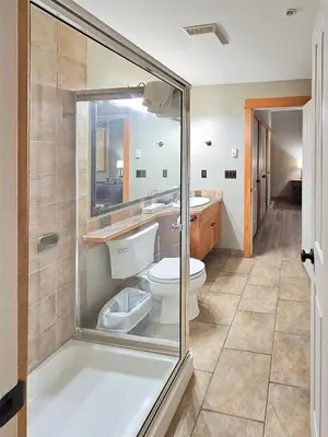 a bathroom with a toilet and a glass shower at Timberline Lodges by Fernie Lodging Co in Fernie