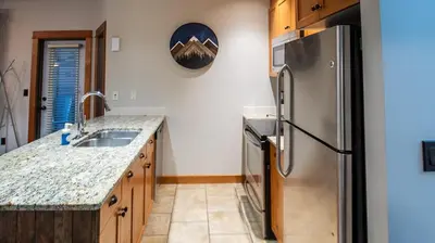 a kitchen with a stainless steel refrigerator and a sink at Timberline Lodges by Fernie Lodging Co in Fernie