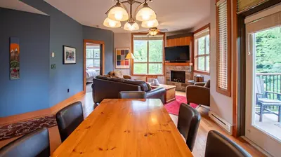 a living room with a wooden table and chairs at Timberline Lodges by Fernie Lodging Co in Fernie