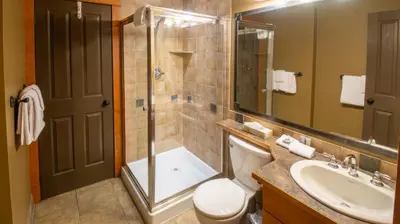a bathroom with a shower and a toilet and a sink at Timberline Lodges by Fernie Lodging Co in Fernie