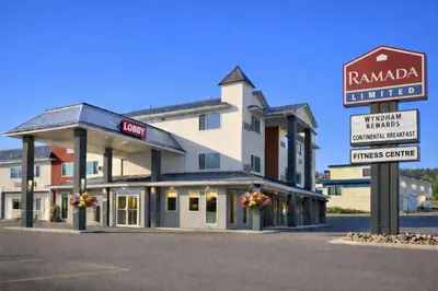 a hotel building with a sign in front of it at Ramada Limited 100 Mile House in One Hundred Mile House
