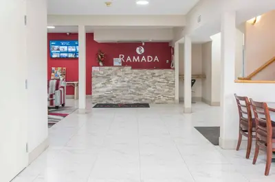 a lobby of a restaurant with a red wall at Ramada Limited 100 Mile House in One Hundred Mile House