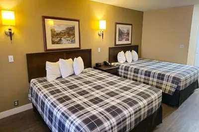 a hotel room with two beds with white pillows at Rodeway Inn & Suites in Kamloops