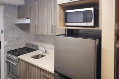 a kitchen with a stainless steel refrigerator and a microwave at Rodeway Inn & Suites in Kamloops