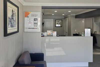 an office lobby with a reception counter and a chair at Rodeway Inn & Suites in Kamloops
