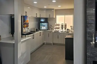 a large kitchen with white cabinets and appliances at Rodeway Inn & Suites in Kamloops