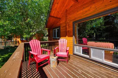 three chairs sitting on a porch of a cabin at Castle Mountain Chalets in Castle Junction