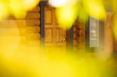 a door to a house with a stone wall at Castle Mountain Chalets in Castle Junction