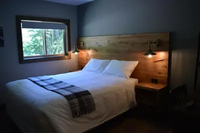 a bedroom with a white bed with a window at Sasquatch Inn in Harrison Mills