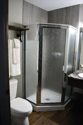 a bathroom with a shower and a toilet at Sasquatch Inn in Harrison Mills
