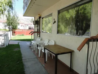 a patio with a table and chairs and a window at Bella Villa Resort Motel in Osoyoos