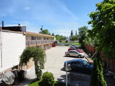 two cars parked in a parking lot next to a building at Bella Villa Resort Motel in Osoyoos