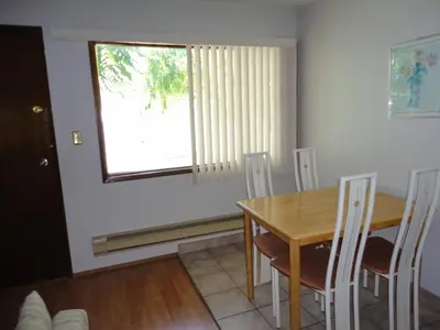 a dining room with a table and chairs and a window at Bella Villa Resort Motel in Osoyoos