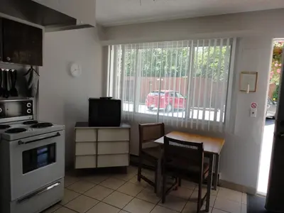a kitchen with a table and a red van outside the window at Bella Villa Resort Motel in Osoyoos