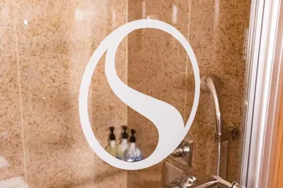 a mirror in a shower with three people in it at SKKY Hotel in Whitehorse