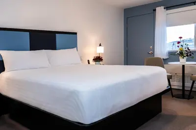 a large white bed in a hotel room at SKKY Hotel in Whitehorse