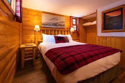 a bedroom with a bed in a wooden room at Baker Creek By Basecamp in Lake Louise
