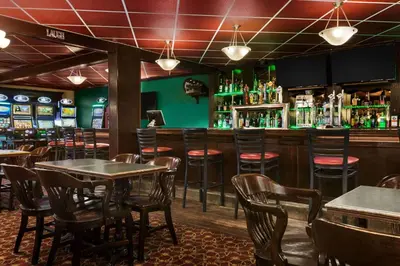 a restaurant with tables and chairs and a bar at Travelodge by Wyndham Lloydminster in Lloydminster
