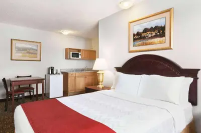 a hotel room with a bed and a kitchen at Travelodge by Wyndham North Battleford in North Battleford