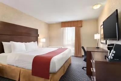 a hotel room with a bed and a desk and a television at Travelodge by Wyndham North Battleford in North Battleford