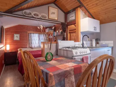 a kitchen and dining room with a table and a stove at Hillside Bungalows in Banff