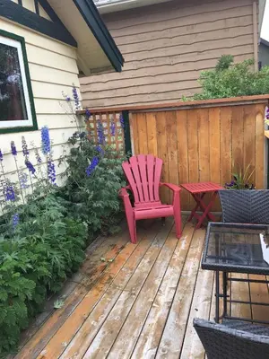 a red chair and a table on a wooden deck at Hillside Bungalows in Banff