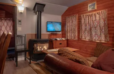a living room with a couch and a stove at Hillside Bungalows in Banff